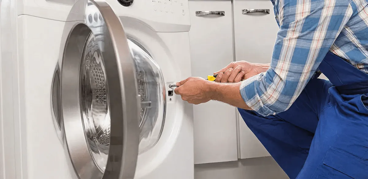 Handyman repairing a clothes dryer and checking electrical connections in South Bend, IN