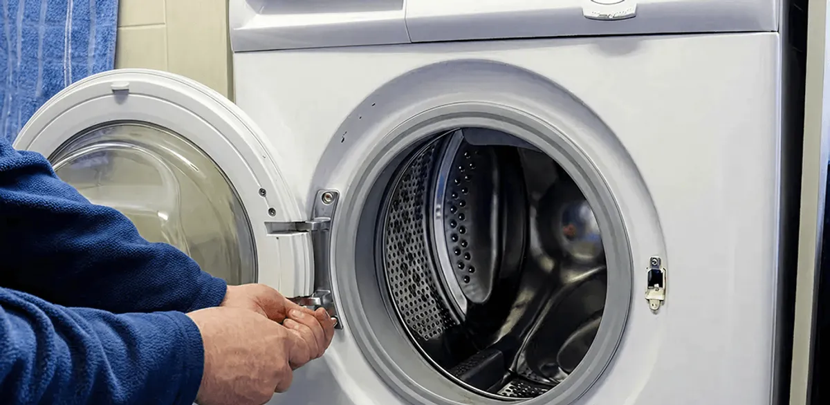 Washing machine repair handyman checking a front-load washer door and latch in South Bend, IN